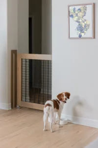 A custom built-in retractable pet gate blends into the architecture of a home.